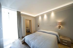 1 dormitorio con cama blanca y ventana en Residence Tabor, en Bardonecchia