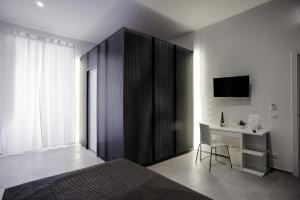 1 dormitorio con 1 cama, escritorio y TV en B&B Girovagando, en Roma