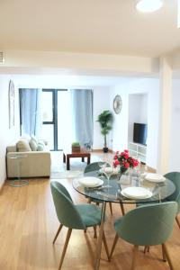Apartments Olé - Albareda 24 في إشبيلية: غرفة طعام مع طاولة وكراسي خضراء