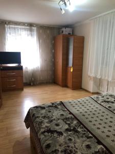 a bedroom with a bed and a dresser and a window at Nocturne Apartment in Chişinău