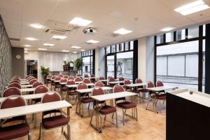 une salle de conférence avec des tables, des chaises et des fenêtres dans l'établissement Scandic Byparken, à Bergen