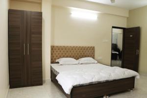 a bedroom with a large bed and a mirror at Radharani Apartment in Kolkata