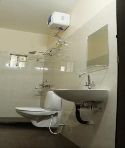 a bathroom with a sink and a toilet at Radharani Apartment in Kolkata