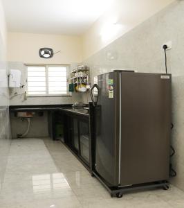uma cozinha com um frigorífico de aço inoxidável e um balcão em Radharani Apartment em Calcutá
