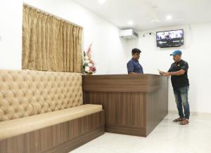 two men standing at a bar in a salon at Radharani Apartment in Kolkata