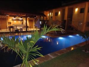 a swimming pool in front of a house at night at Apartamento Sossego in Luis Correia
