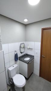 uma casa de banho com um WC branco e um lavatório. em Apartamento Sossego em Luís Correia