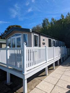 a small house with a white picket fence at Caravan Littlesea Haven Weymouth Amazing Views in Weymouth