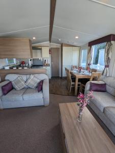 uma sala de estar com dois sofás e uma mesa em Caravan Littlesea Haven Weymouth Amazing Views em Weymouth