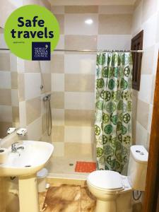 La salle de bains est pourvue d'un lavabo, de toilettes et d'une douche. dans l'établissement RALUX house, à São Tomé