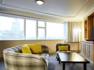 a living room with a couch and a table at Mercure Liverpool Atlantic Tower Hotel in Liverpool