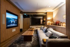 - un salon avec un grand canapé et une télévision à écran plat dans l'établissement Mercure Grenoble Centre Alpotel, à Grenoble