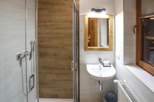 un bagno con lavandino e doccia con specchio di Chata Gościnna Waluś a Białka Altre 58 foto