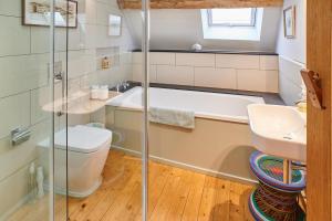 e bagno con vasca, servizi igienici e lavandino. di Host & Stay - Penrheol Farmhouse a Brecon
