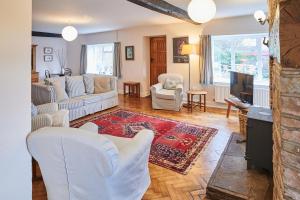 sala de estar con muebles blancos y TV en Host & Stay - Penrheol Farmhouse, en Brecon