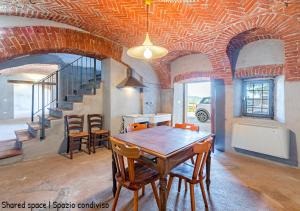 Casa di nonna Ines 1 - Hideaway in Monferrato con Vista sulle Colline, Solarium e Piscina في Gabiano: غرفة طعام مع طاولة وكراسي خشبية