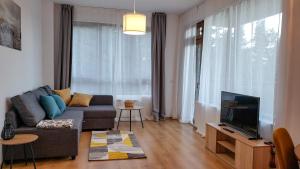 a living room with a couch and a tv at Semiramida Gardens Apartments in Borovets