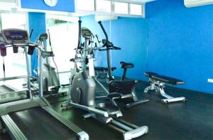 un gimnasio con equipo cardiovascular en una sala azul en Bitec Bts Bangna New Luxury room, en Ban Khlong Samrong