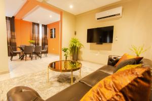 uma sala de estar com um sofá e uma mesa em Accra Luxury Homes @ Achimota em Lapaz