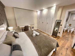 a bedroom with a large bed with two towels on it at Hideaway Plaza Mayor Salamanca in Salamanca
