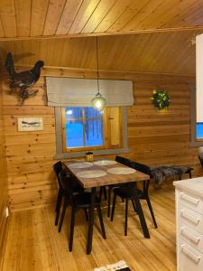 una sala da pranzo con tavolo e sedie in una cabina di Lomanaamanka Villa Kanerva a Syöte