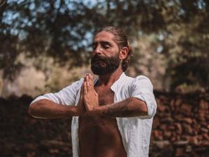 Un homme avec une barbe debout avec ses mains priantes dans l'établissement Agroturismo Sa Talaia-Adults Only, à Sant Antoni de Portmany