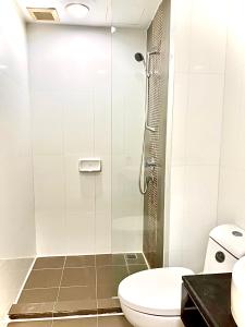 a bathroom with a toilet and a glass shower at Bitec Bts Bangna New Luxury room in Ban Khlong Samrong