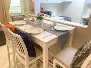 a dining room table with plates and flowers on it at Manchester Regency - 2BR Apartment in Dubai Marina in Dubai
