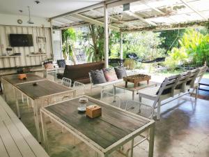 un soggiorno con tavoli e sedie in legno di Glur Hostel ad Aonang Beach