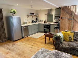 a kitchen with a refrigerator and a couch in a room at Charming 2-Bed Cottage in Otley in Otley