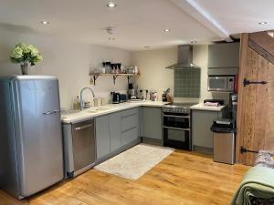 una cocina con nevera y electrodomésticos de acero inoxidable en Charming 2-Bed Cottage in Otley en Otley