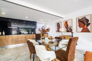 una cucina e una sala da pranzo con tavolo e sedie in vetro di BeGuest Albufeira Luxus Villa ad Albufeira