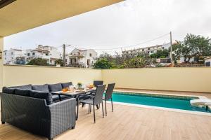 una sala da pranzo con tavolo e sedie accanto alla piscina di BeGuest Albufeira Luxus Villa ad Albufeira