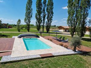 una piscina en un patio con 2 sillas en Logement de charme en campagne girondine: le Domaine de Mongeret, en Pondaurat