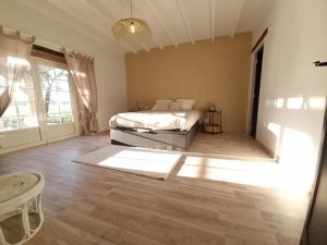 1 dormitorio con cama y ventana grande en Logement de charme en campagne girondine: le Domaine de Mongeret, en Pondaurat