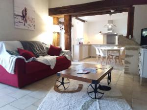 sala de estar con sofá rojo y mesa en Logement de charme en campagne girondine: le Domaine de Mongeret, en Pondaurat