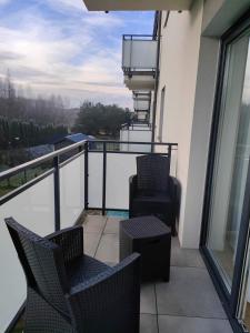 uma varanda com 2 cadeiras e vista para a água em Apartament Złoty 4 em Zblewo