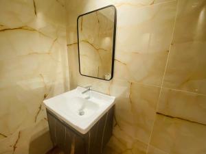 een badkamer met een wastafel en een spiegel bij Manchester Regency - 2BR Apartment in Dubai Marina in Dubai