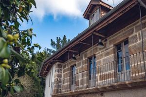 Edificio antiguo con ventanas y balcón en Houmi As Bouzas, en Castrelo de Miño