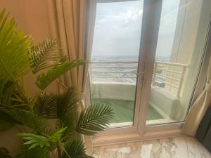 een kamer met een glazen schuifdeur en een raam bij Manchester Regency - 2BR Apartment in Dubai Marina in Dubai