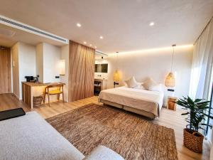 a hotel room with a bed and a desk at S´Estancia Suites in Es Mercadal +79 photos