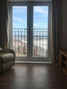 a room with a large window with a view of the beach at Beachfront pet friendly townhouse, Stunning views in Port Talbot