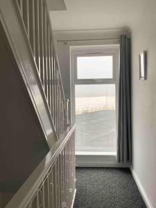 a hallway with a large window and a staircase at Beachfront pet friendly townhouse, Stunning views in Port Talbot