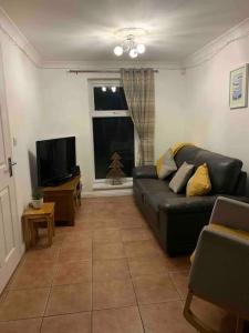 a living room with a couch and a television at Beachfront pet friendly townhouse, Stunning views in Port Talbot