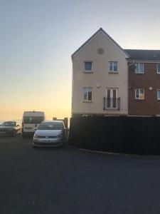 a car parked in a parking lot next to a building at Beachfront pet friendly townhouse, Stunning views in Port Talbot