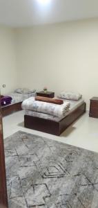 Habitación con 3 camas y alfombra. en شقه فندقيه.Apartment,Petra, en Wadi Musa