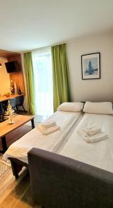 1 dormitorio con 2 camas grandes y cortinas verdes en Popović apartmani, Sunčani breg, en Kopaonik