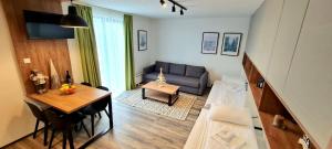 una sala de estar con una mesa y un sofá en Popović apartmani, Sunčani breg, en Kopaonik