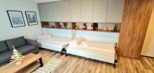 una sala de estar con dos camas y un sofá en Popović apartmani, Sunčani breg, en Kopaonik 40 fotos más