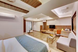 1 dormitorio con 1 cama y sala de estar en Click Hotel by Suba, Jamnagar, en Jamnagar
